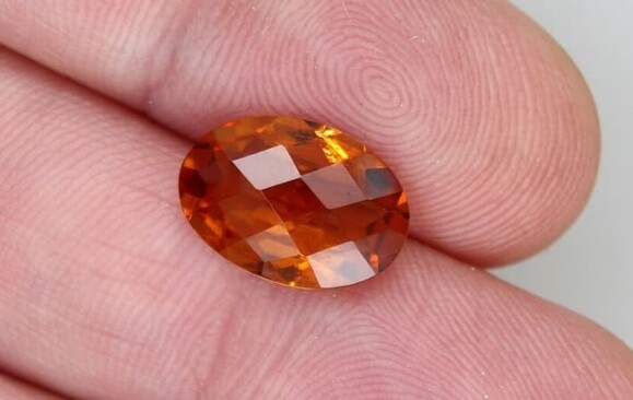 Piedra preciosa naranja con talla oval.